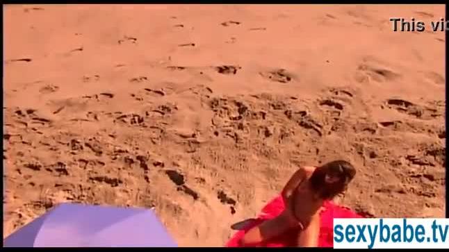 Tanned superbabe rubs herself on sandy beach